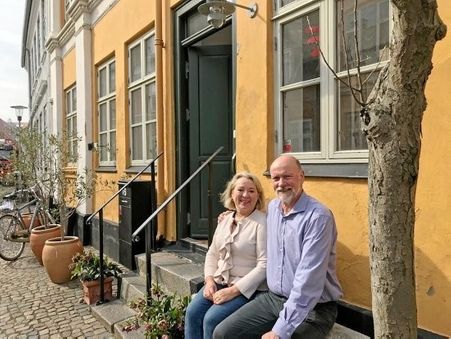 Ægteparret Jane Kjølbye og Thomas Møller på bænken foran deres hus i Slottensgade, hvor de også har sat træer i krukker op.